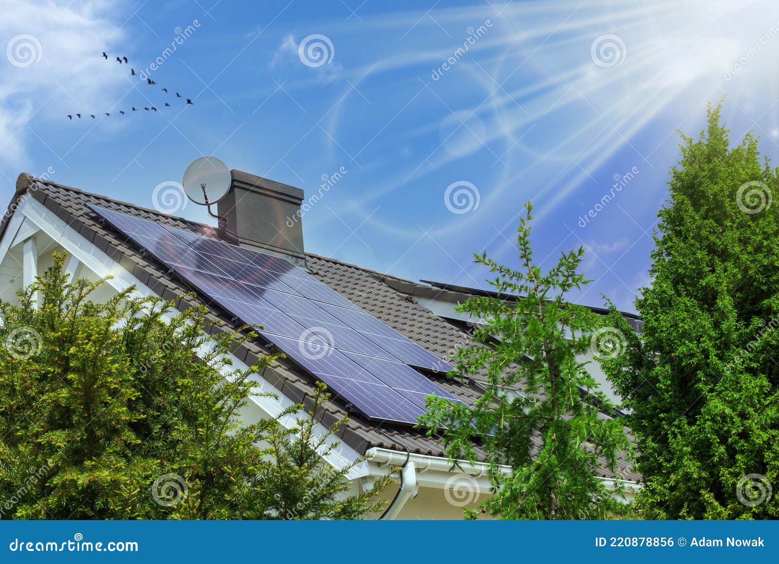 a modern house with solar panels on the roof. clear sky, rays of the sun. green