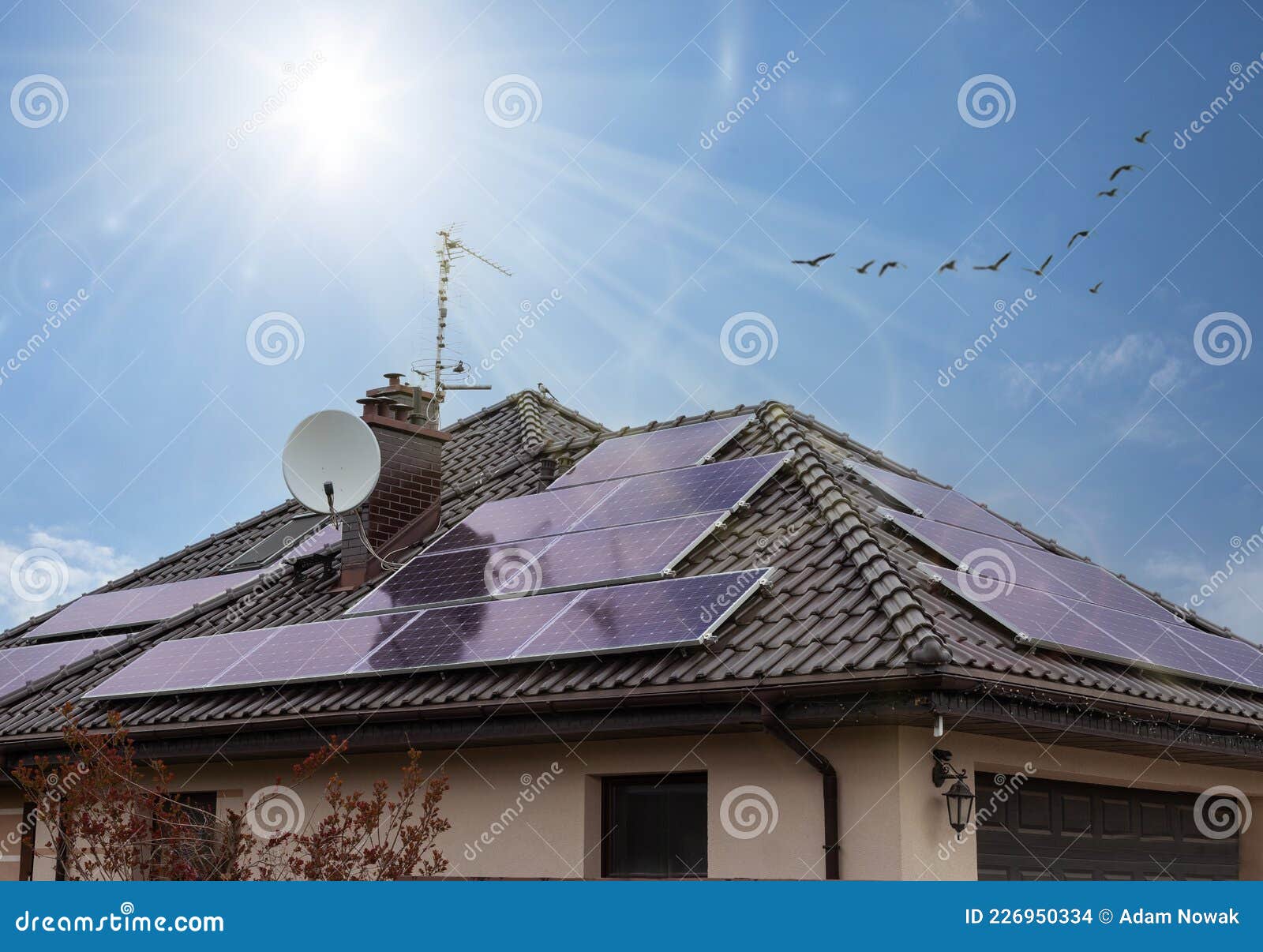 beautiful modern house with solar panels. clear sky, sunrays