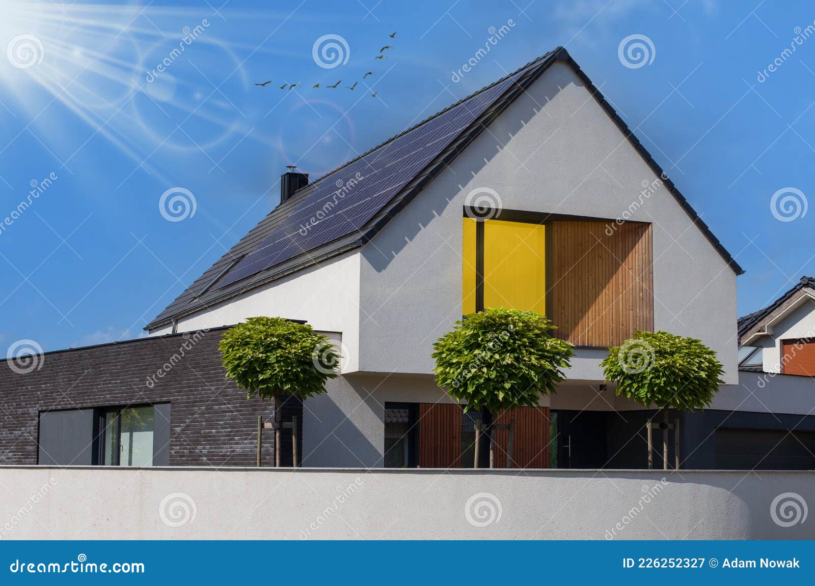 modern house with solar panels and pool. clear sky and ray sun