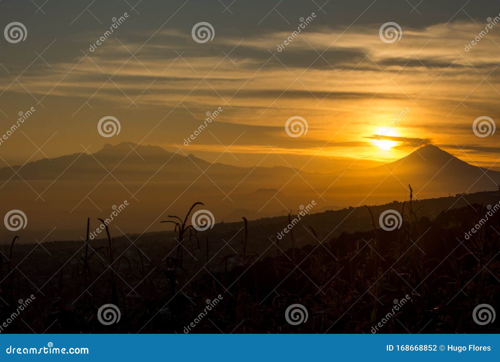 solar sphere above the volcanoes at dawn