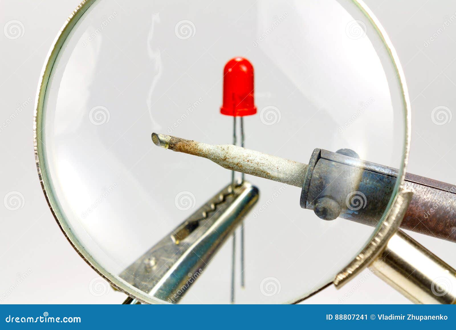 Soldering Iron and Red LED Diode through a Magnifying Glass Stock Image