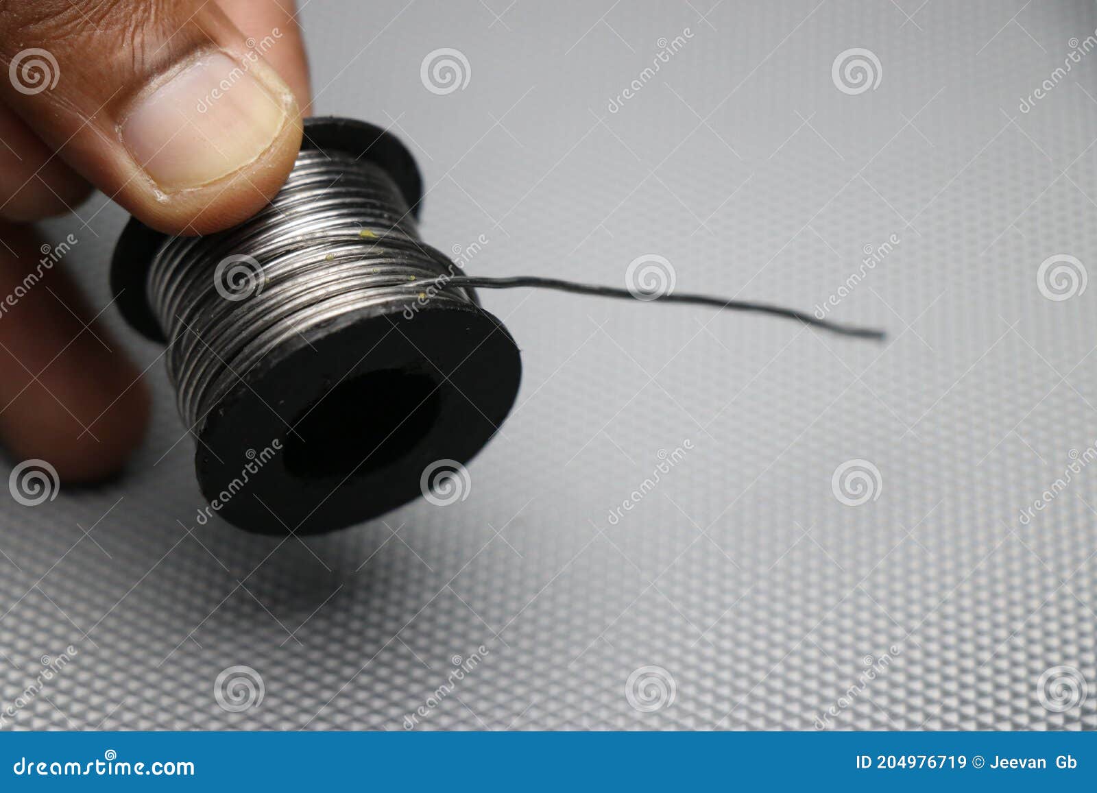 Soldering Wires or Soldering Lead Roll Held in Hand. Solder Lead Used