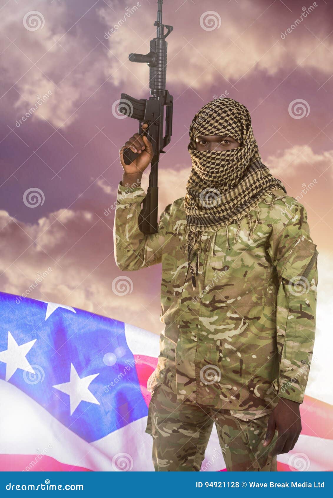Soldier with Weapon in Front of American Flag and Clouds Stock Photo