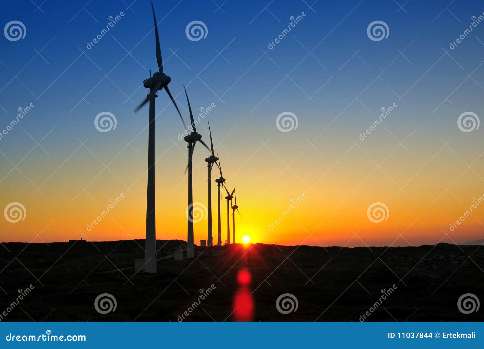 Solnedgångwindmills. Windmills för solnedgång för energimiljösky