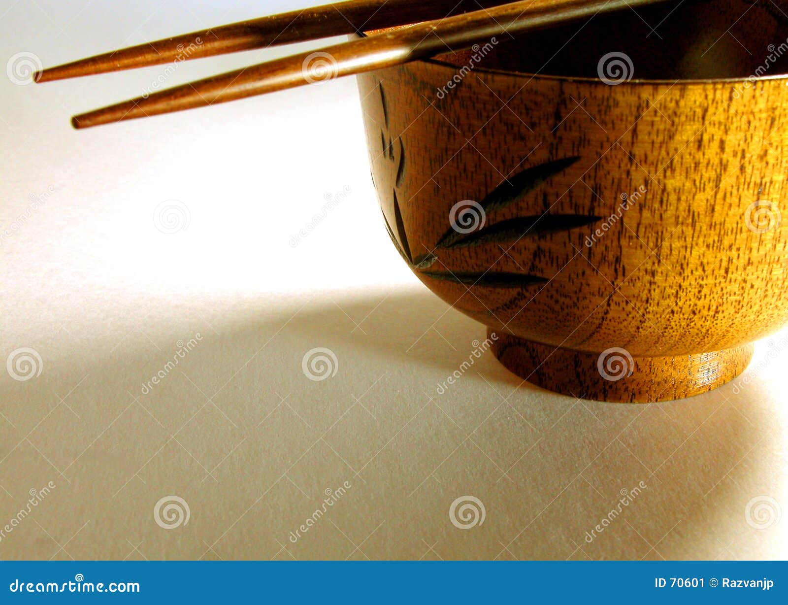 Sombras asiáticas. Un tazón de fuente de madera, dos palillos y una iluminación interesante.