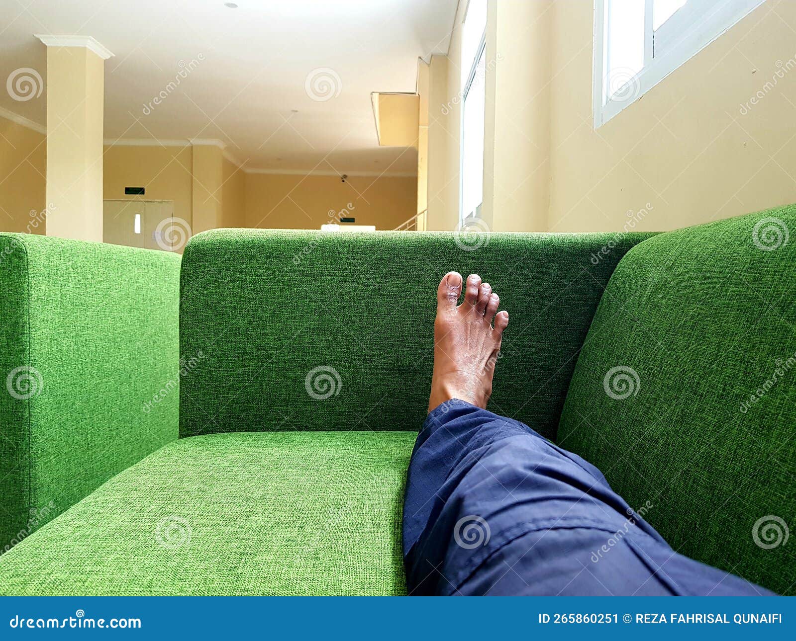 Someone& X27;s Legs Stretched Out on the Green Sofa Stock Image Image
