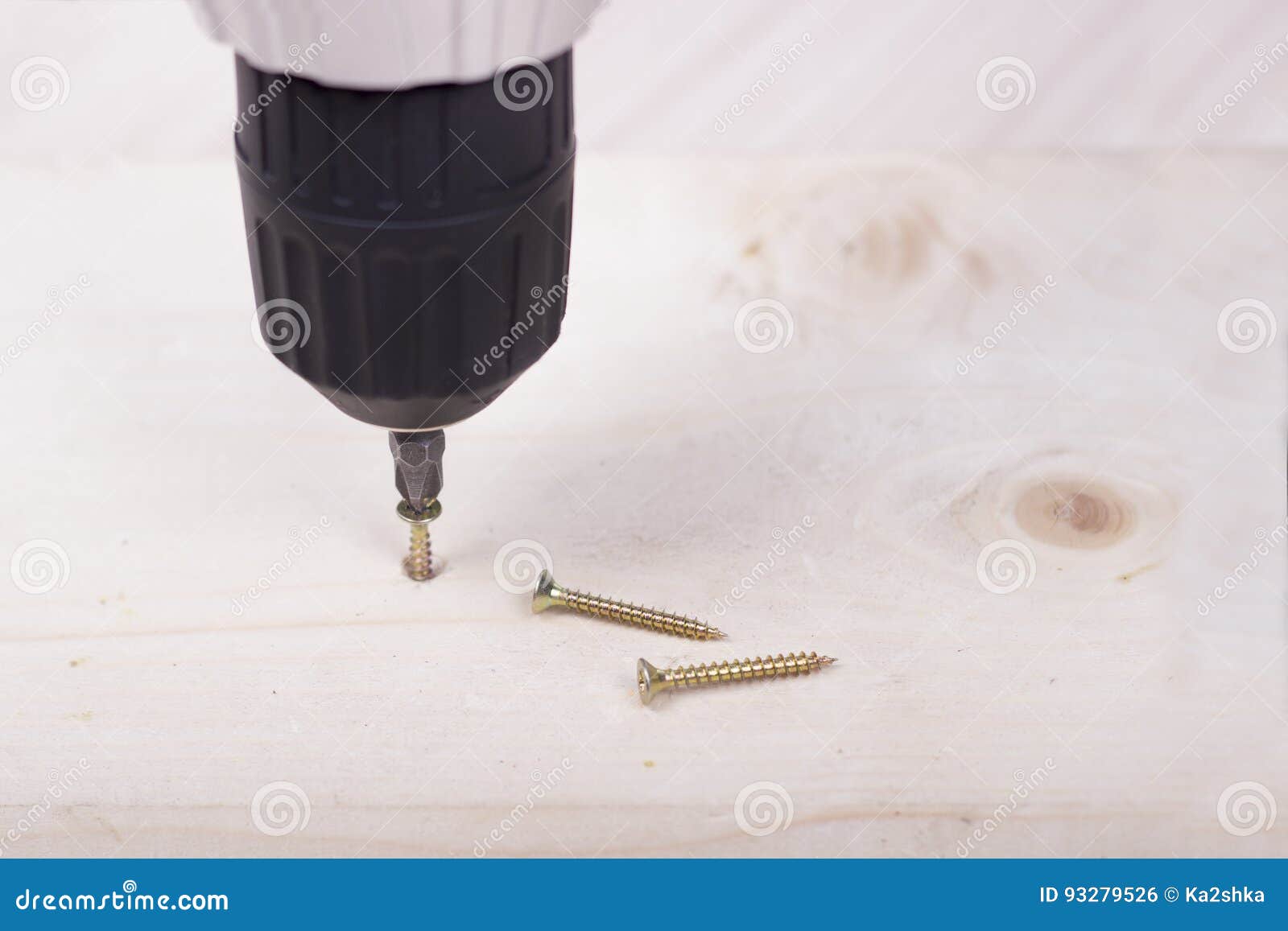 Someone is Screwing a into Wooden Surface with the Screwdriver. DIY