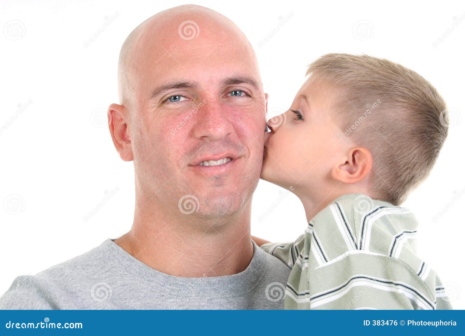 Son Kissing Dad On The Cheek. Four year old boy kissing his dad on the cheek. Close-up, headshot over white.
