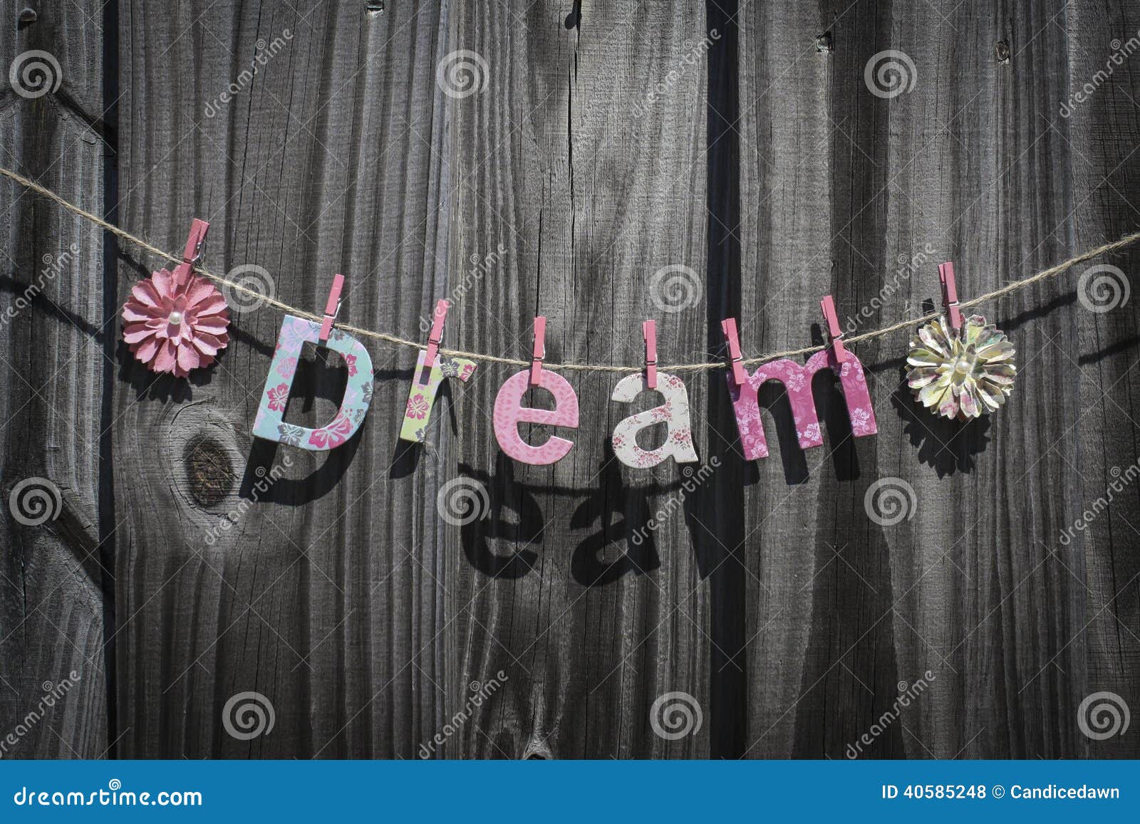 A palavra 'sonho' que pendura em uma corda contra uma cerca