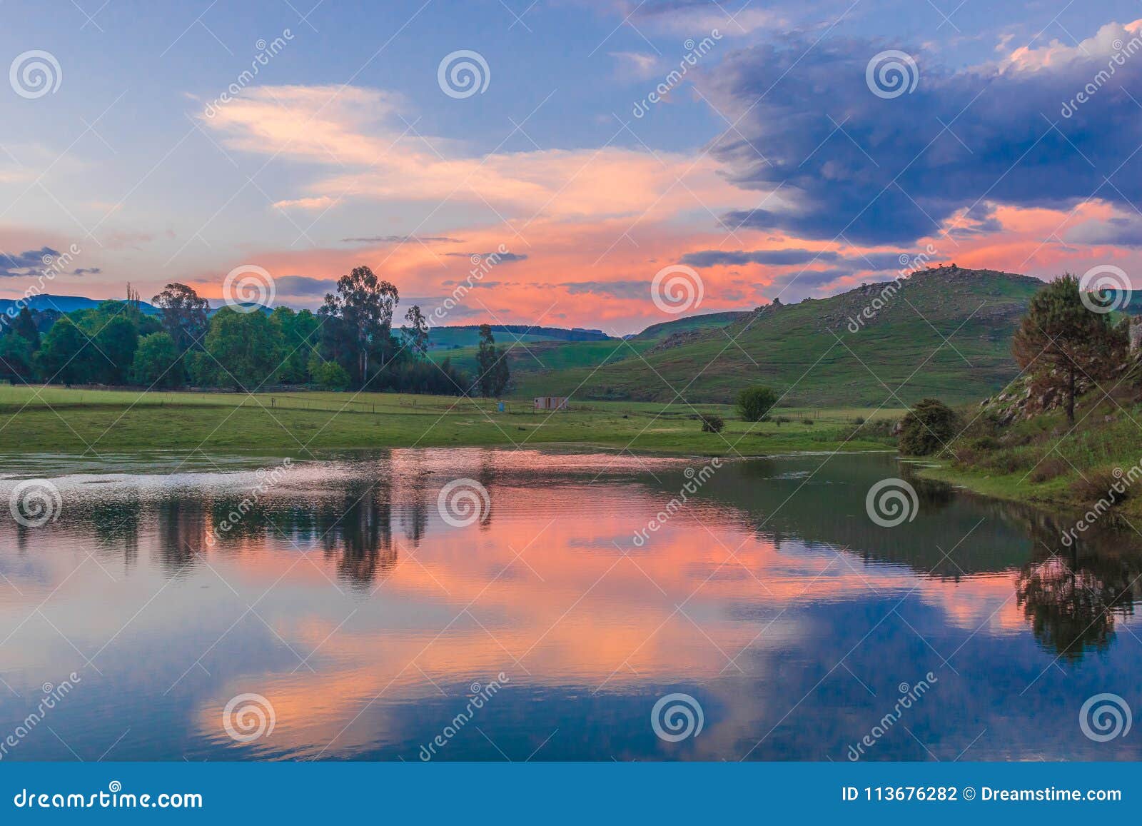 Sonnenuntergang in Drakensbergen Khotso, Südafrika. Eine schöne Reflexion in einem See in einer Umwelt von Khotso, Drakensbergen - Südafrika