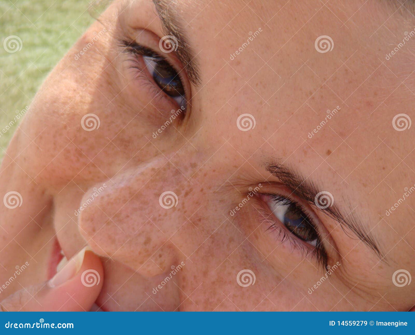 Sonrisa pecosa y ojos marrones. Ciérrese encima del retrato de una sonrisa hermosa pecosa de la mujer