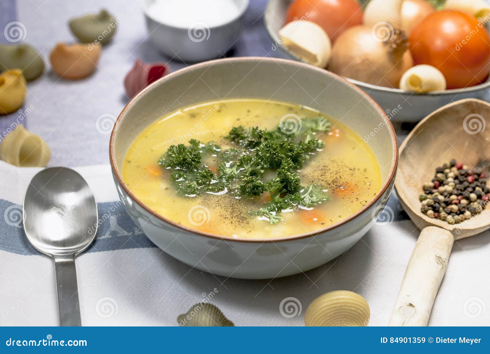 Sopa de macarronete da galinha com cenouras e salsa em uma bacia cinzenta