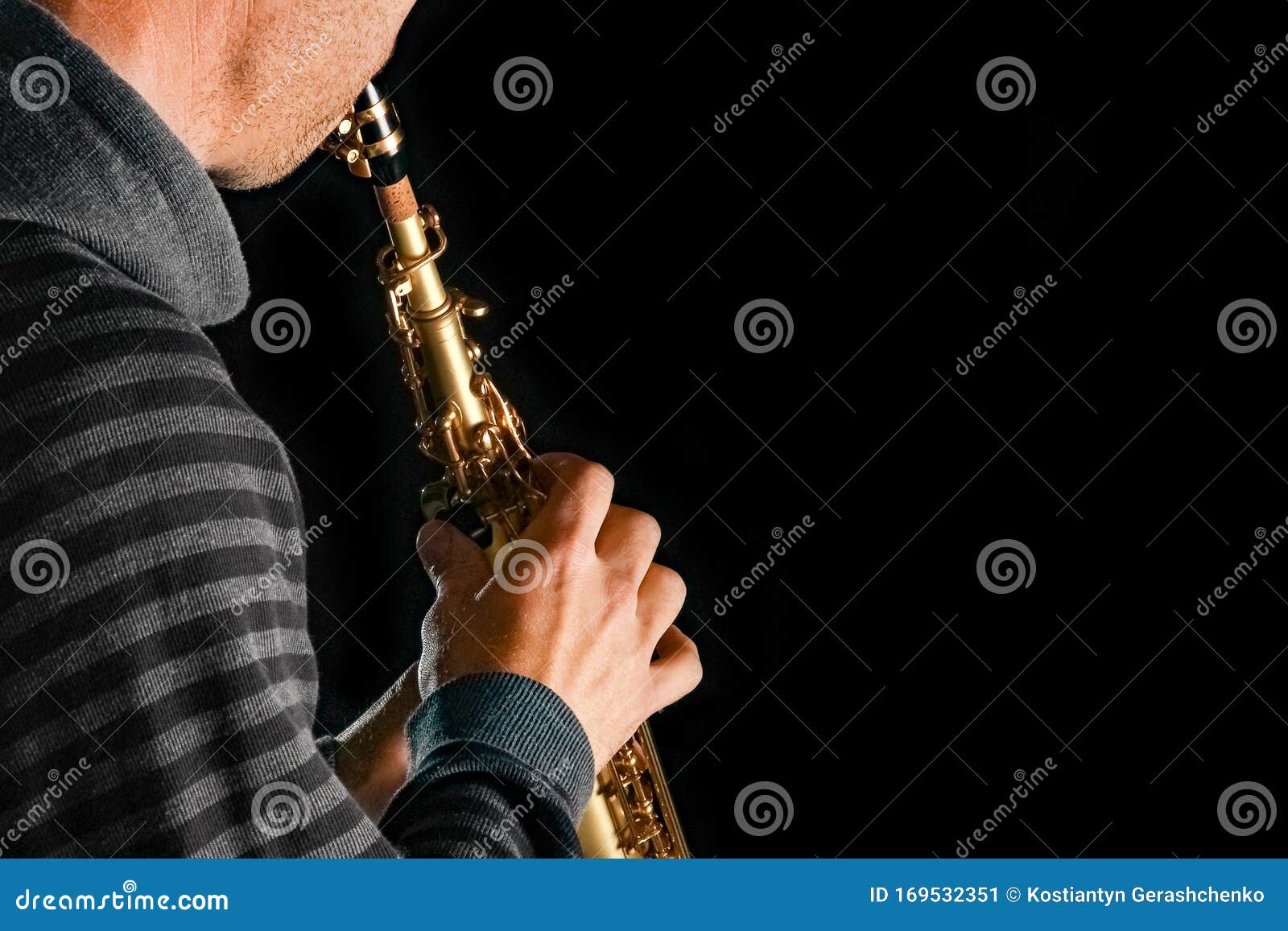 soprano saxophone in the hands of a guy on a black background