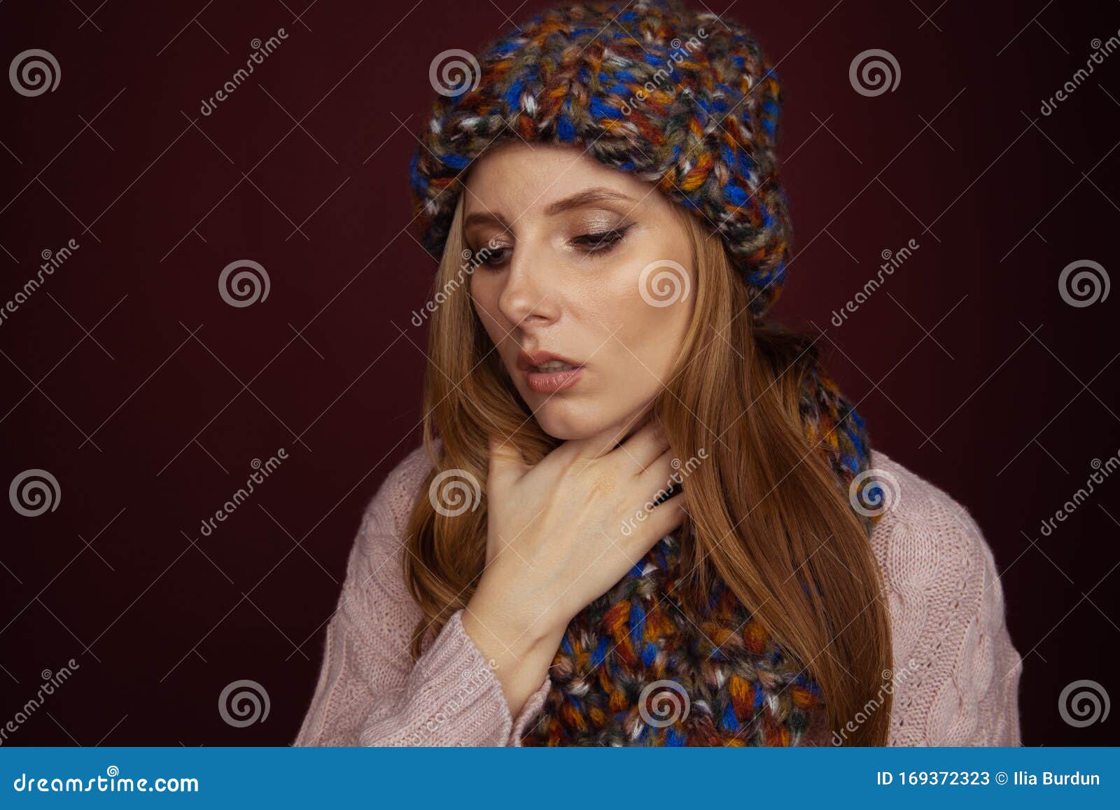 sore throat concept. sick woman in hat and scarf holding her nech and felling bad.