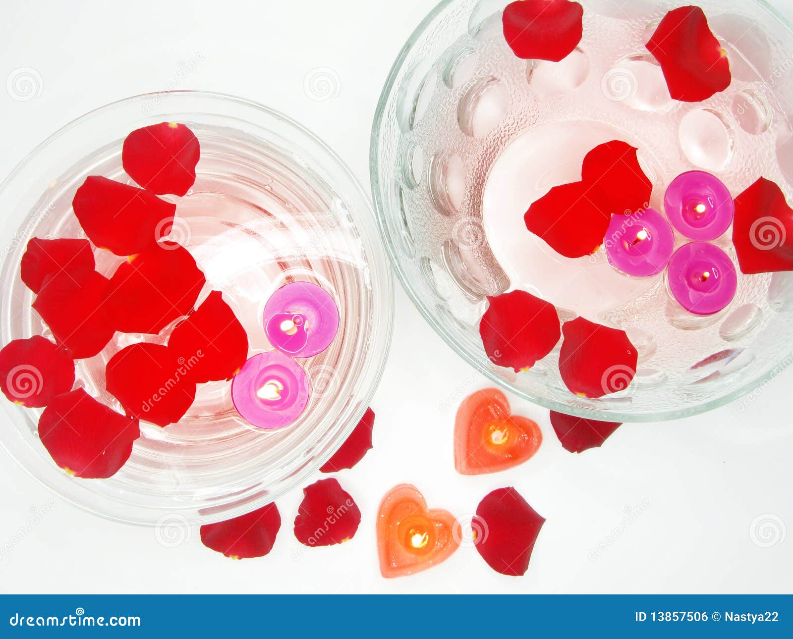 Spa bowls with red rose petals and candles. Spa floating scented candles among red rose petals