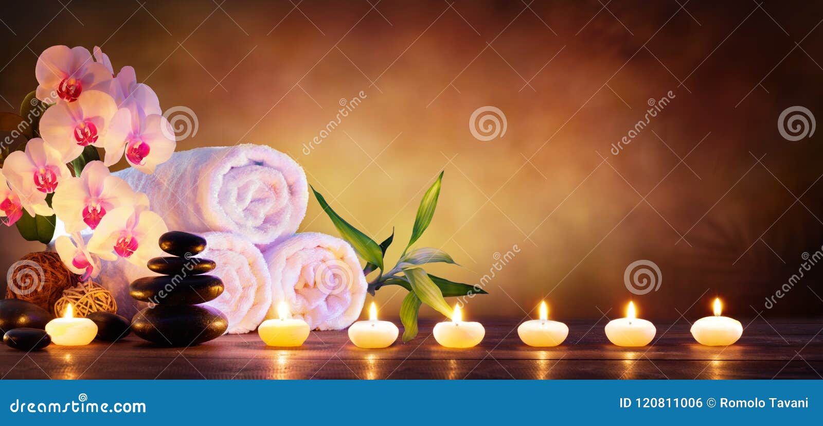 spa concept - massage stones with towels and candles