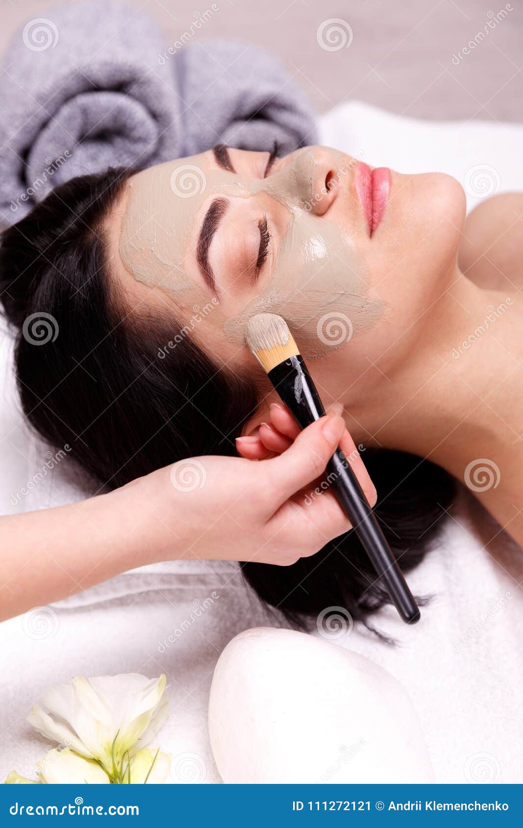spa facial mask application. beautiful relaxed woman having clay face mask in the spa