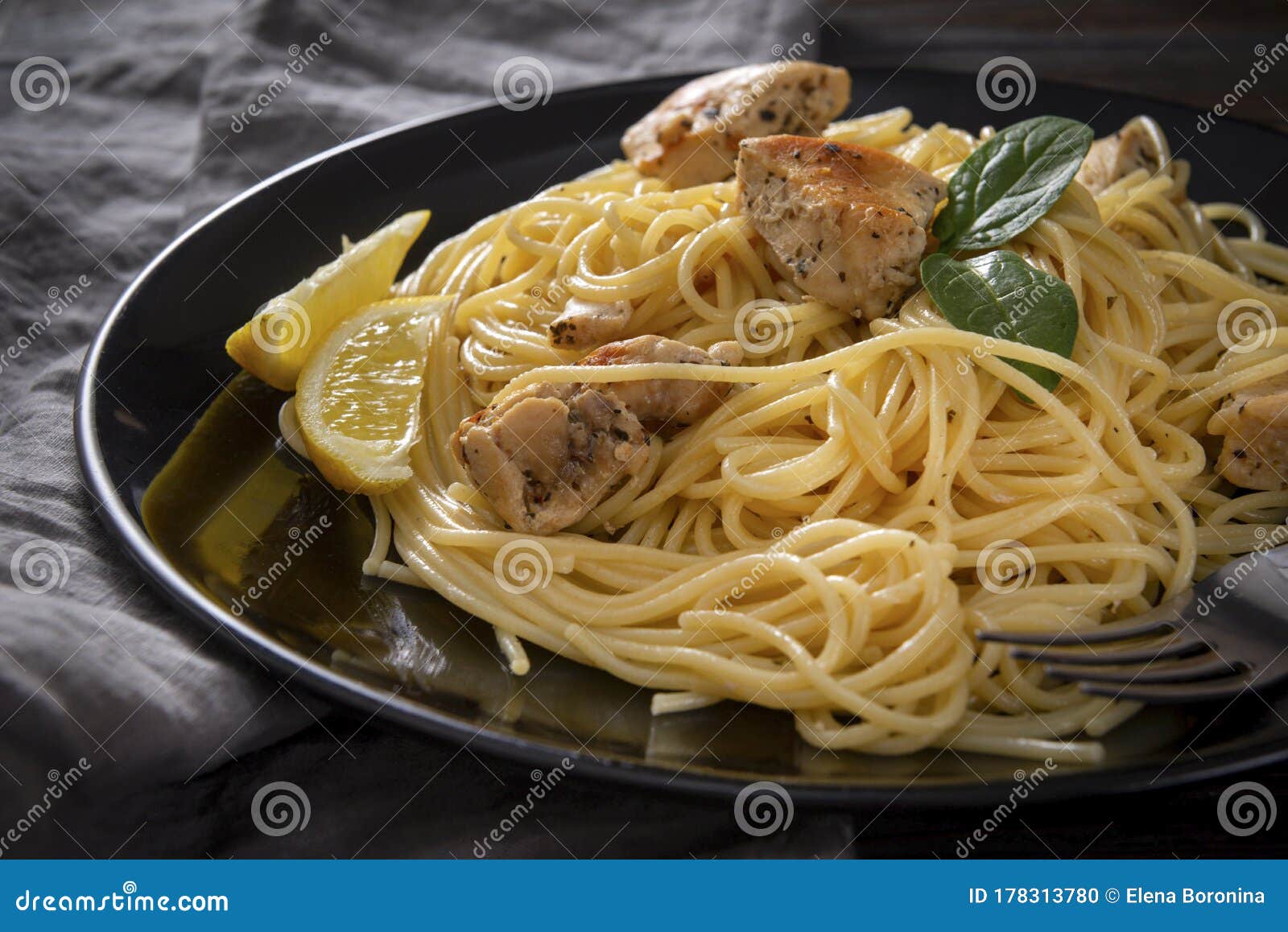 Spaghetti with Chicken on a Black Plate , Napkin, on a Dark Wooden ...