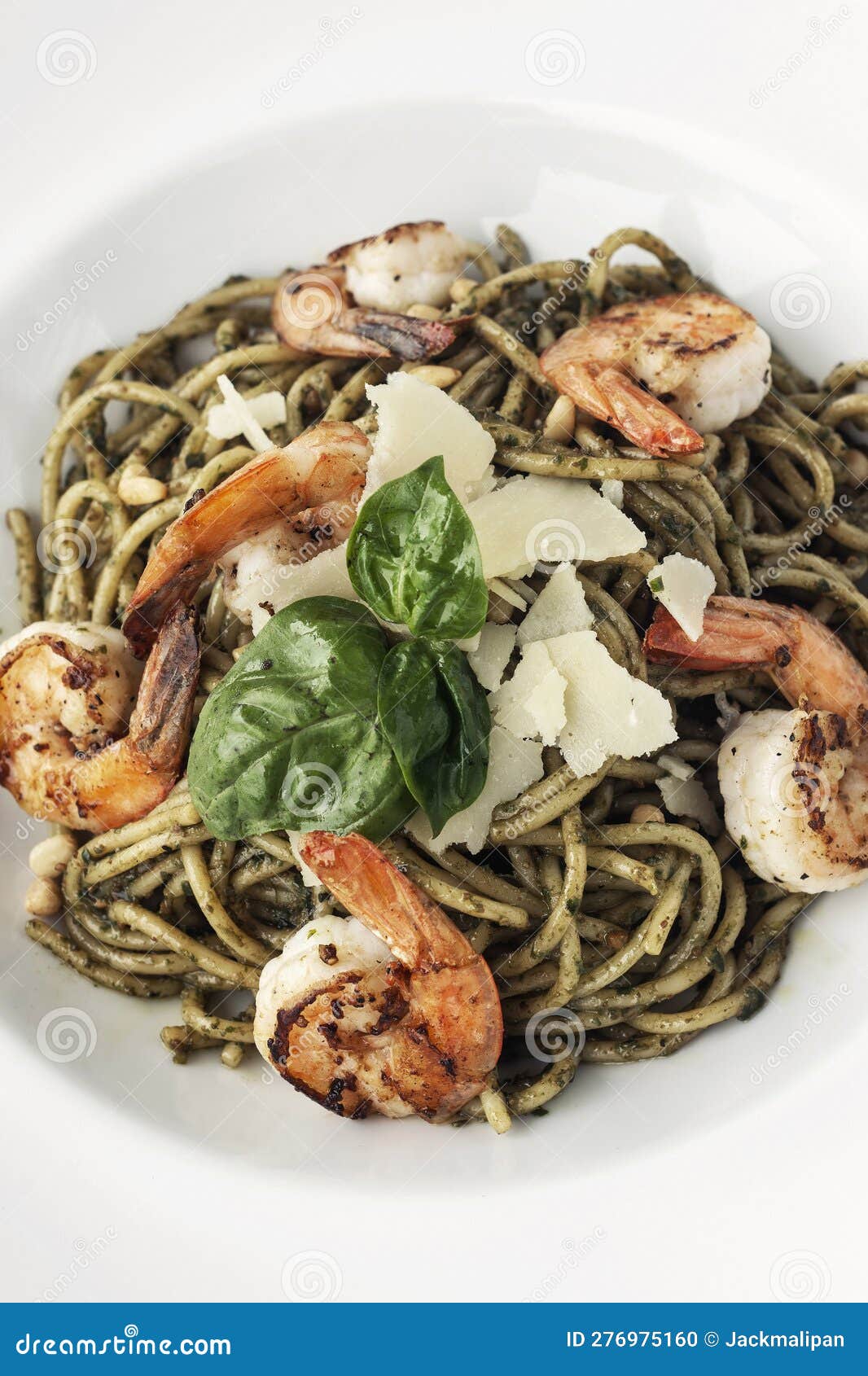 spaghetti gamberi pasta with prawns and pesto on white background