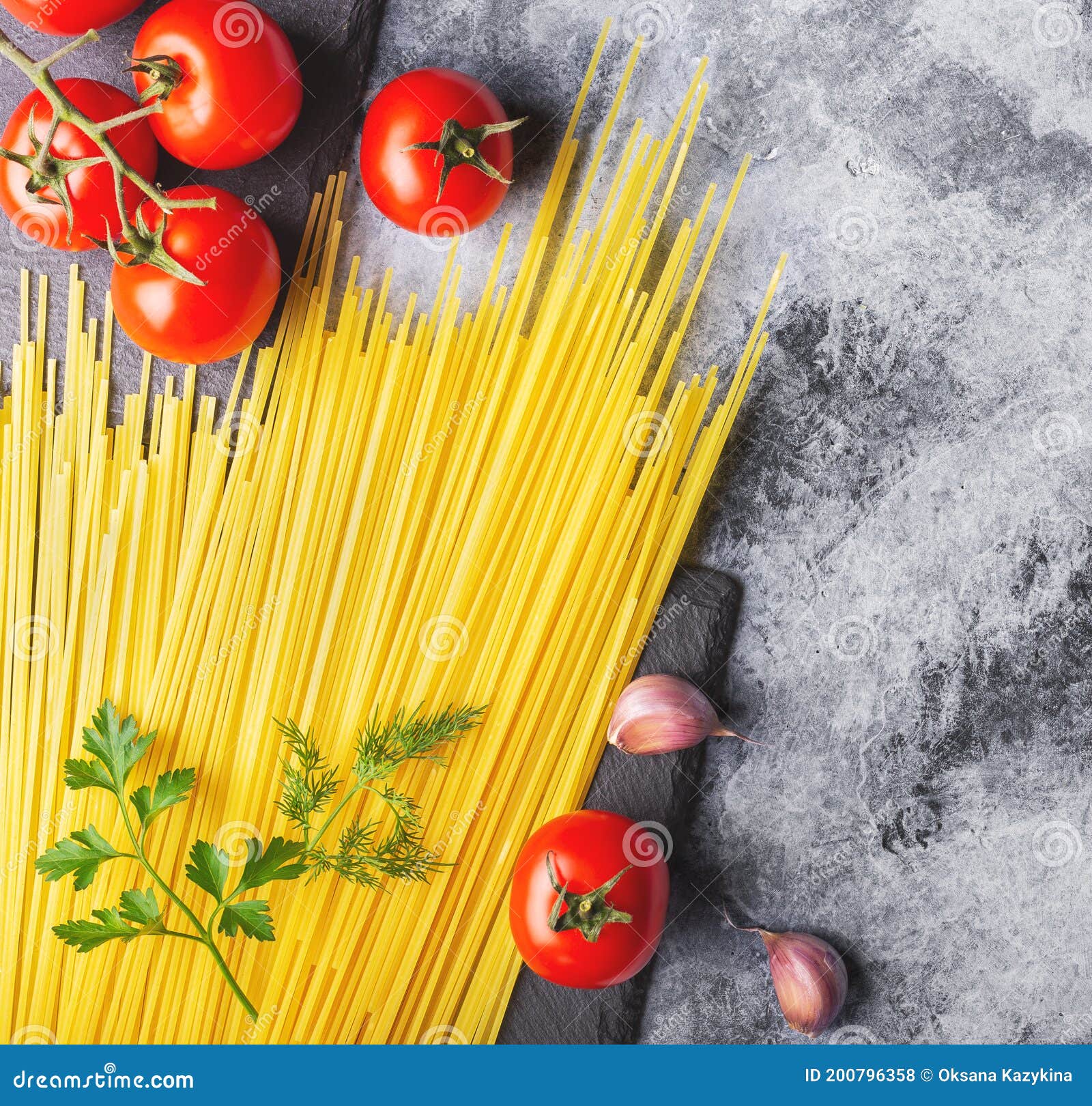 Spaghetti Pasta, Red Tomatoes, Garlic and Herbs the Table Stock Photo