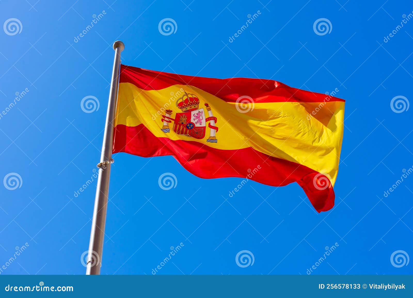 Spanish flag on blue sky stock image. Image of ripple 256578133