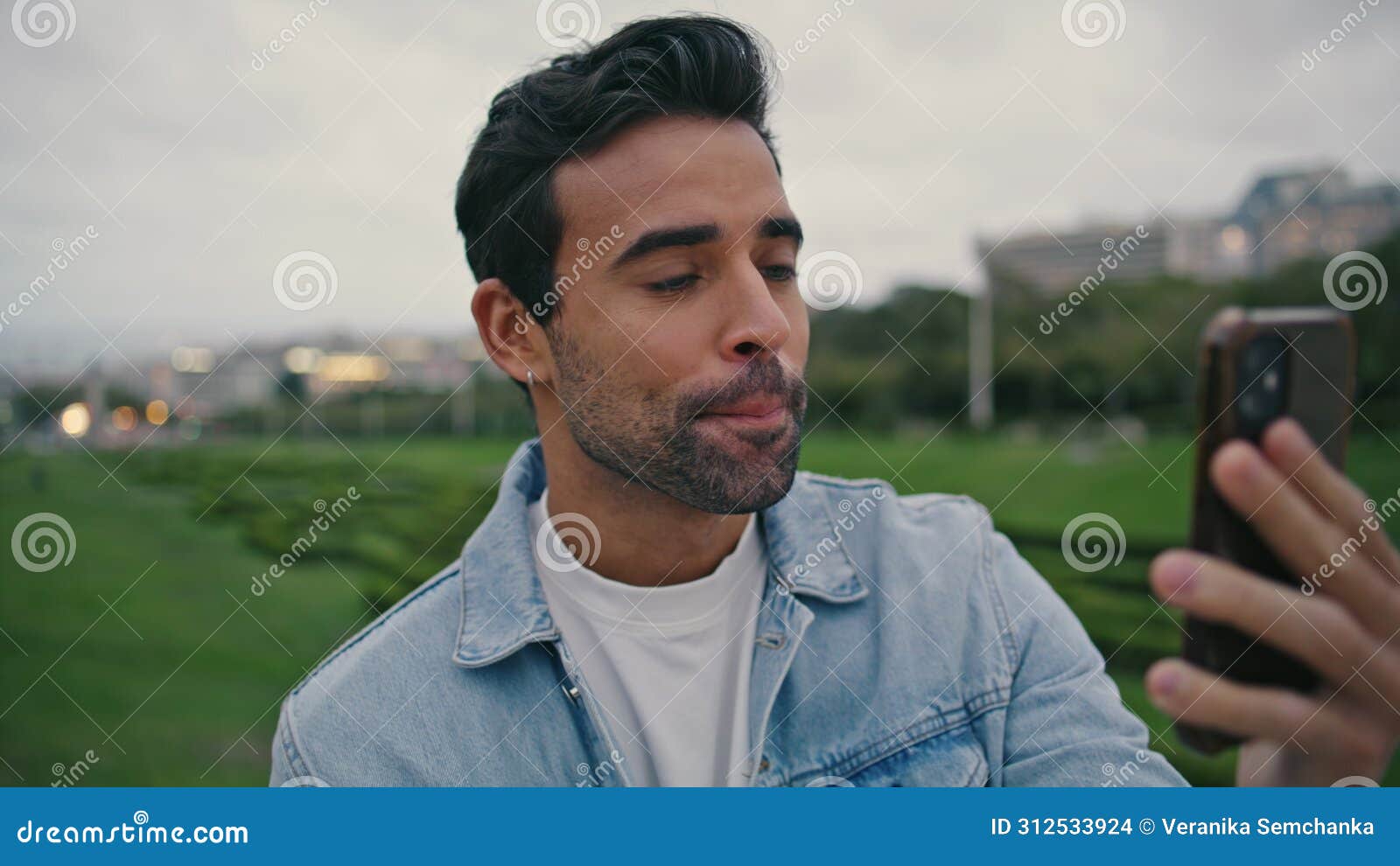 spanish man videocalling smartphone at evening nature close up. guy video call