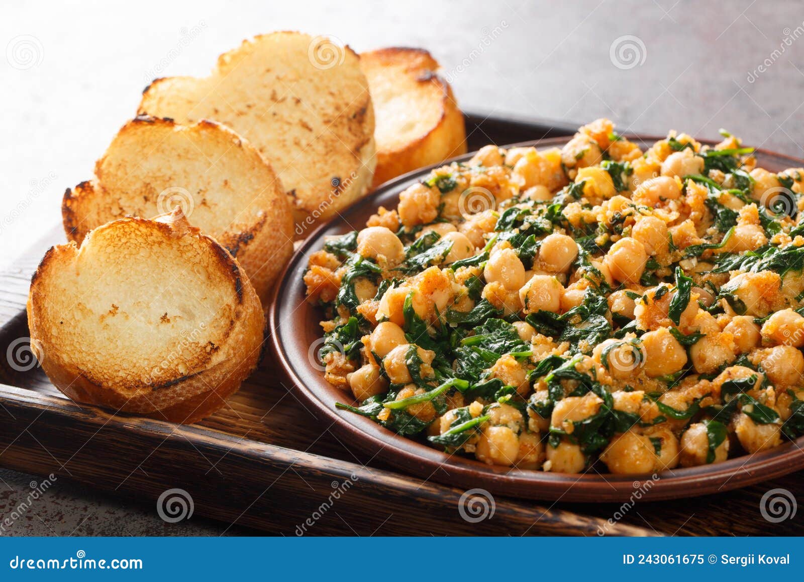 Spanish Spinach and Chickpeas Served with Toasts Closeup in the Plate