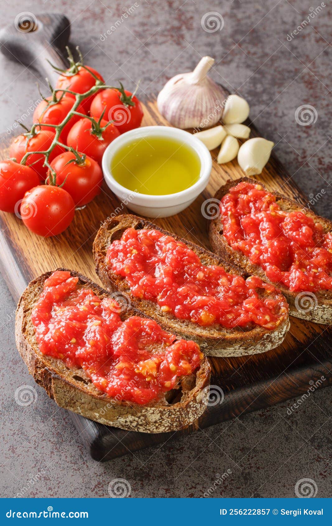 spanish style toast with tomato pan con tomate closeup on the wooden board. vertical