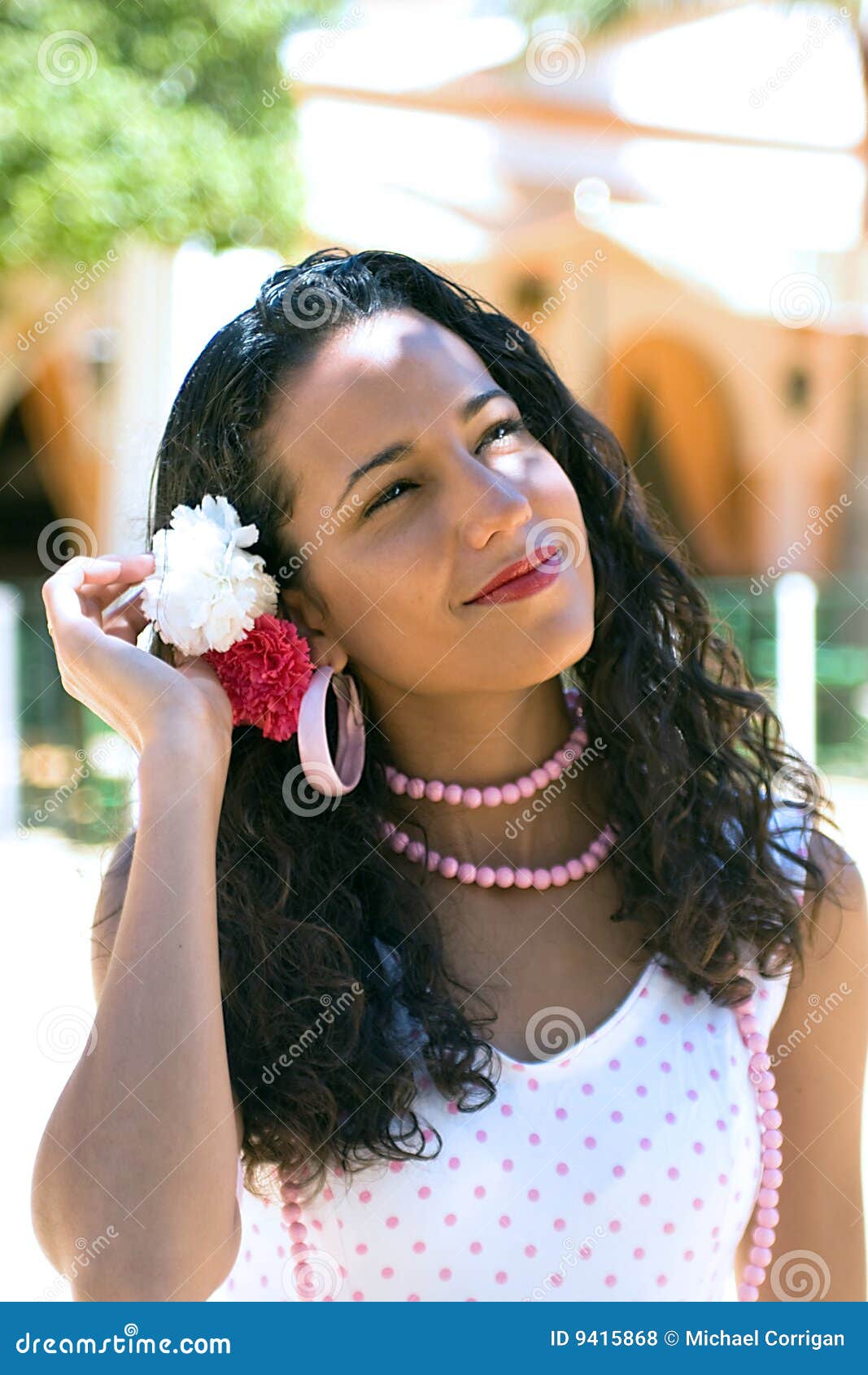 spanish woman in feria dress adjusts hair