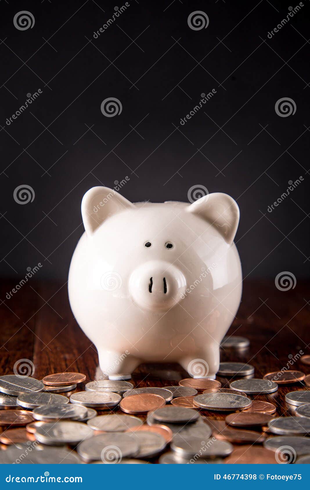 Spargris & mynt. Spargris på det mörka ädelträgolvet som omges av spridda mynt/USD pengar med en svart bakgrund