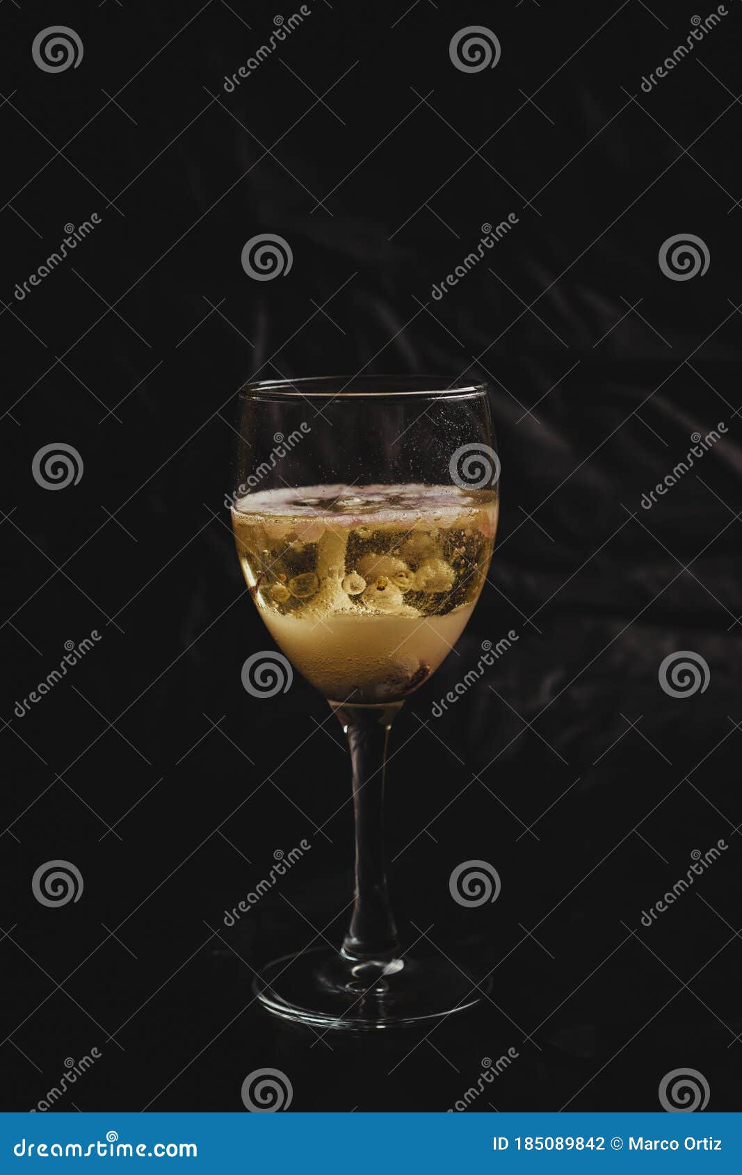 sparkling wine in a cocktail, freshly served in a small glass, the foam and the gas can be perceived perfectly