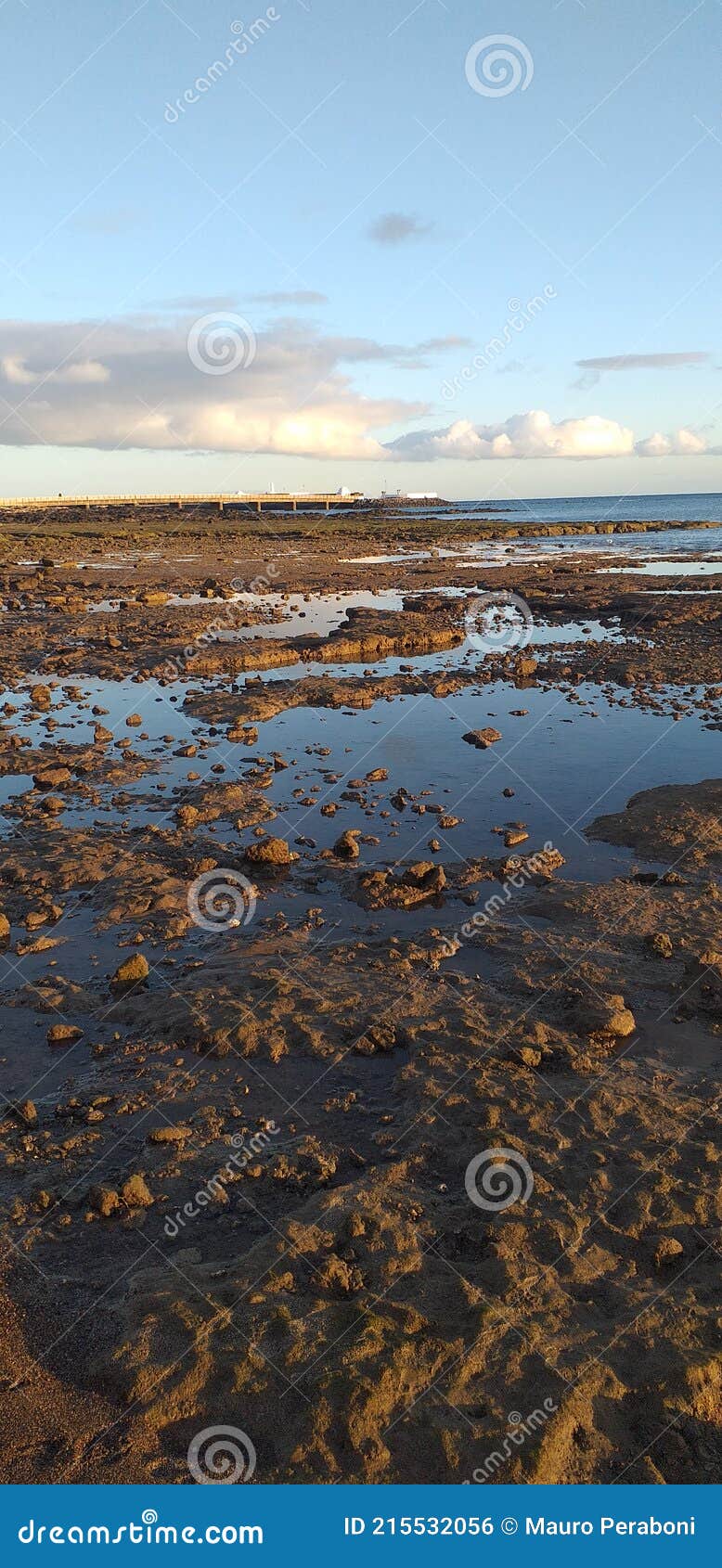 specchio di acqua tra rocce con cielo riflesso