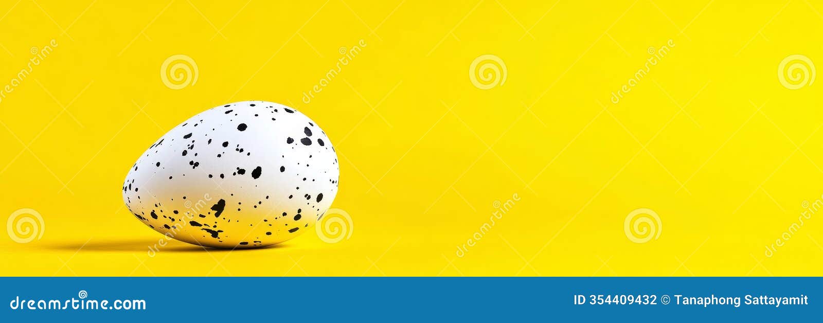 speckled egg on yellow background spring easter new life celebration simple  a single speckled egg rests on a