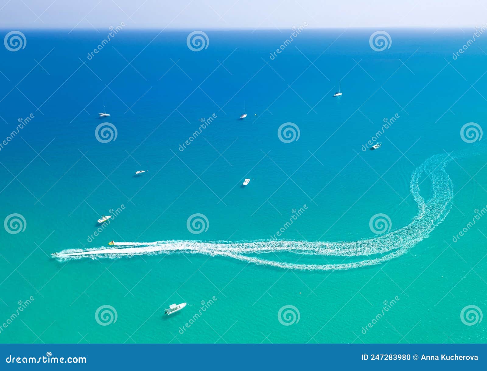 speedboat leaves spray trail on sea water. watersports at seaside, aerial seascape