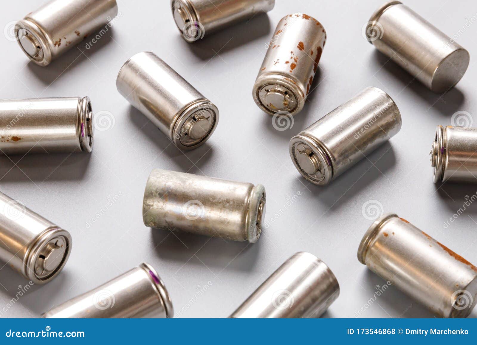 spent used rechargeable nickel metal hydride ni-mh battery, grey background, flat lay