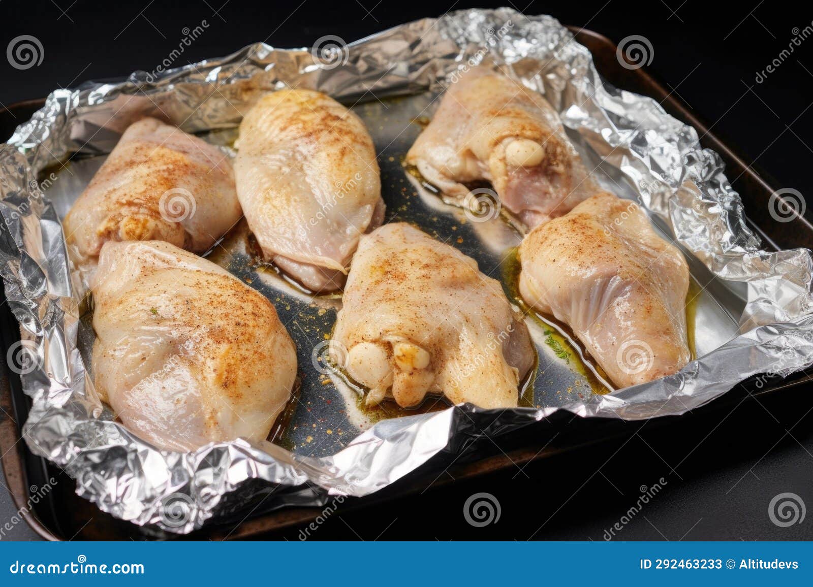 Spiced Chicken Wings Wrapped in Aluminum Foil Ready for Baking Stock