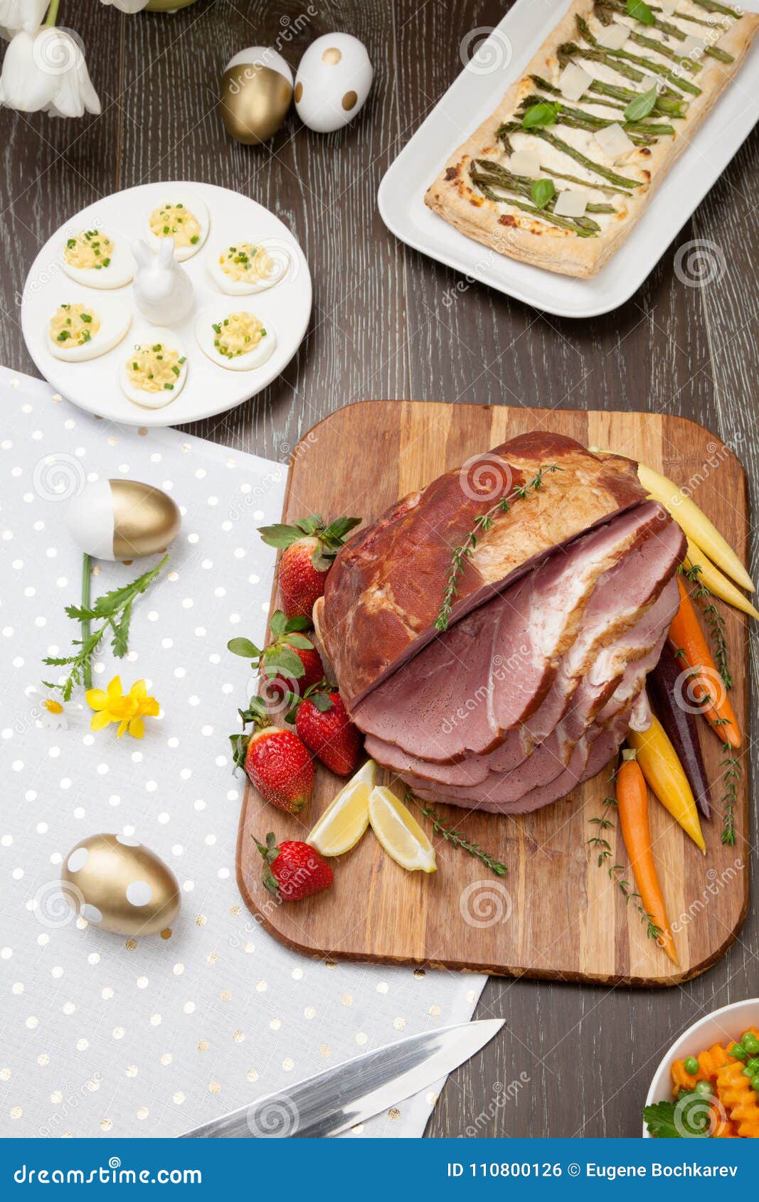 Spicey Ham For Easter. Delicious spicey roasted ham with deviled eggs, asparagus parmesan pastry, butternut squash with green peas, baby carrots, strawberries, and Easter decoration.