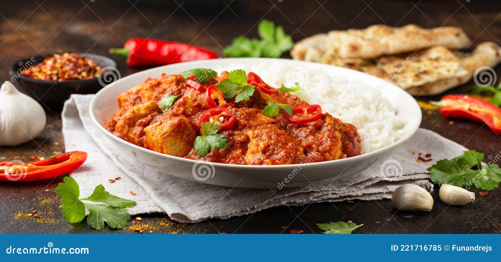 spicy chicken pathia curry with basmati rice in a white plate. healthy food.