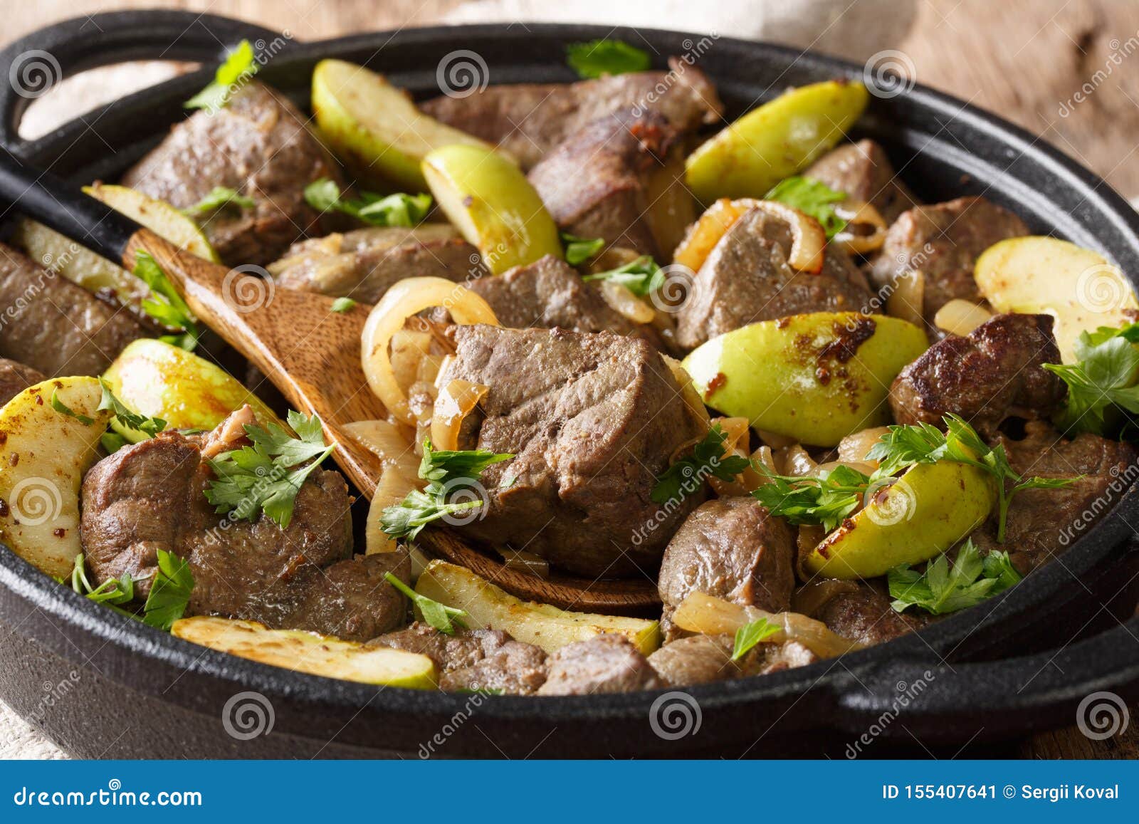 Spicy Fried Beef Liver with Apples and Onions Closeup in a Pan