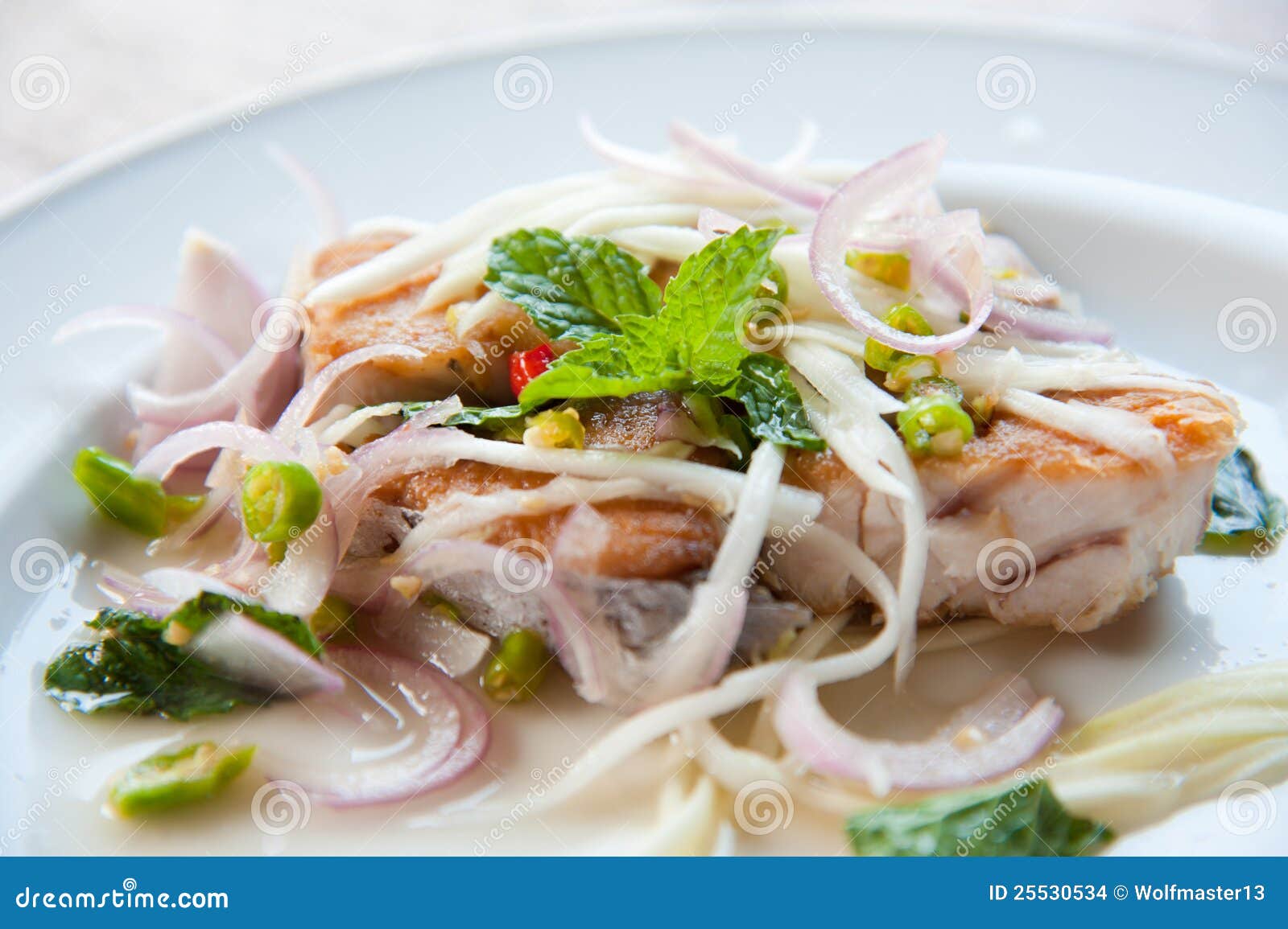Spicy Salad with Fried Fish and Green Herb in Thai Stock Photo Image