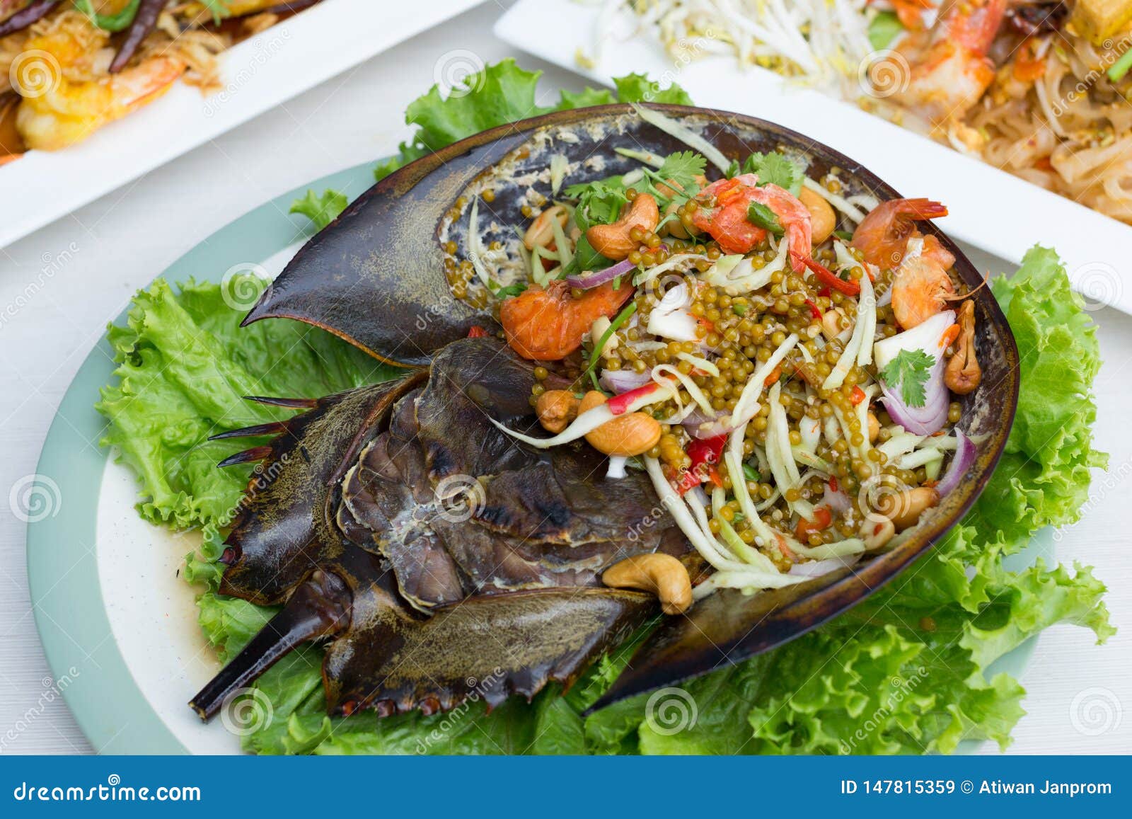 Spicy Salad Horseshoe Crab Egg with Lettuce in White Dish on Table