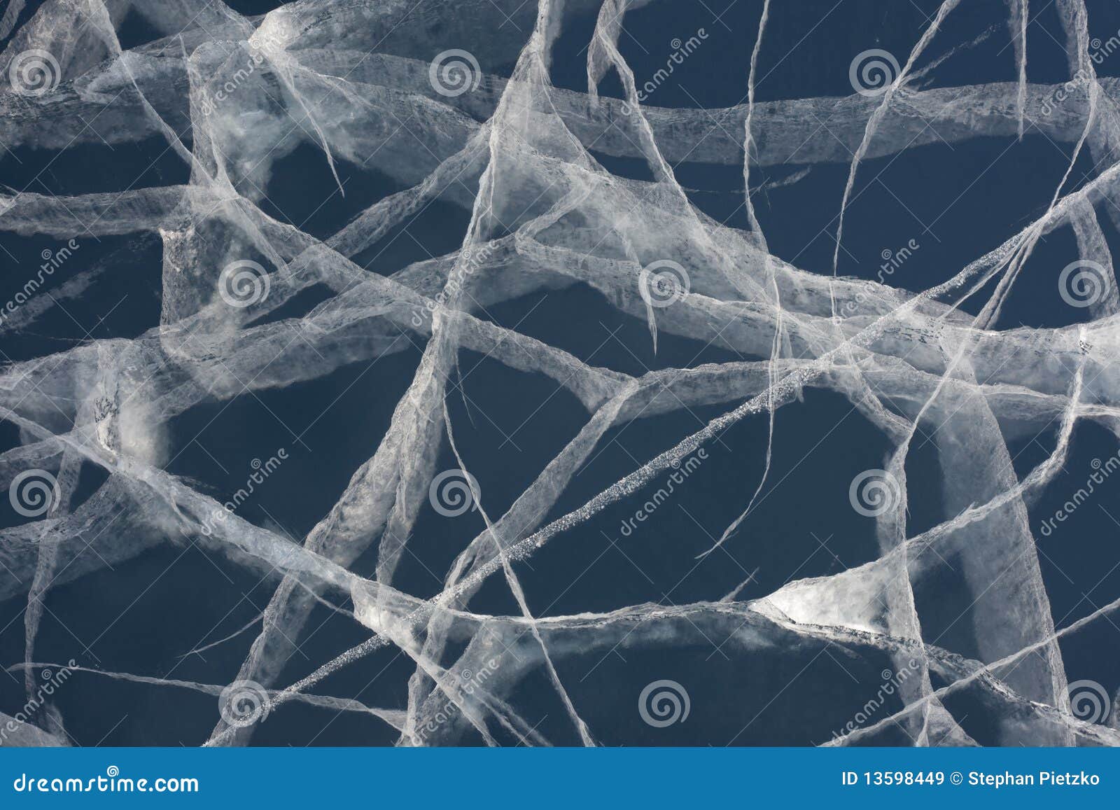 spider web of tension cracks in thick layer of ice