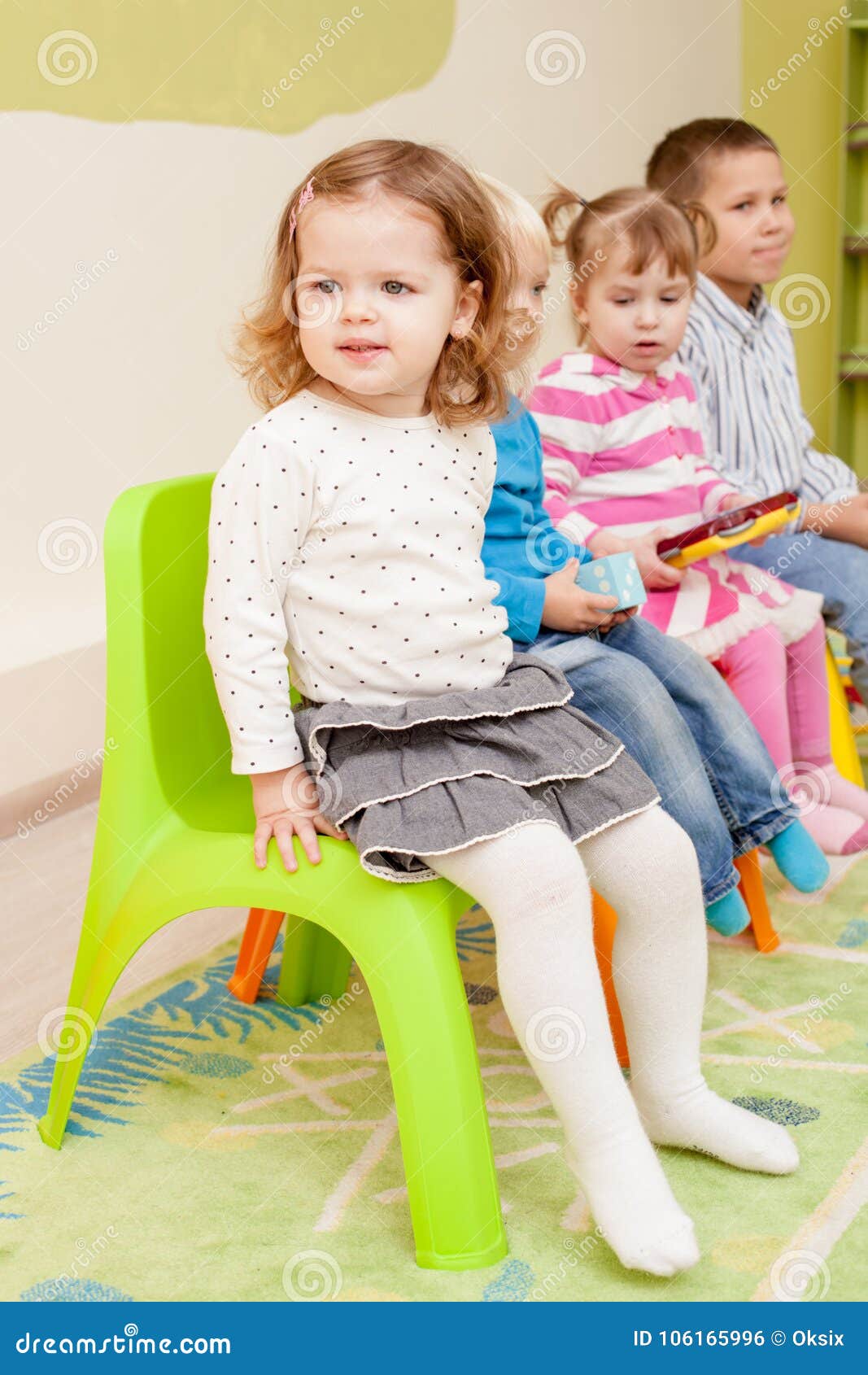 Spiele im Kindergarten. Kinder im Kindergarten, der auf den Stühlen sitzt und hören etwas