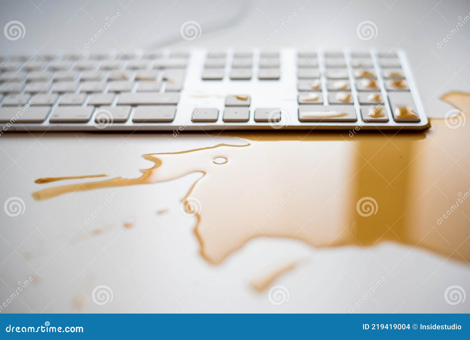 Spilled Drops of Black Coffee on a White Computer Keyboard Stock Photo