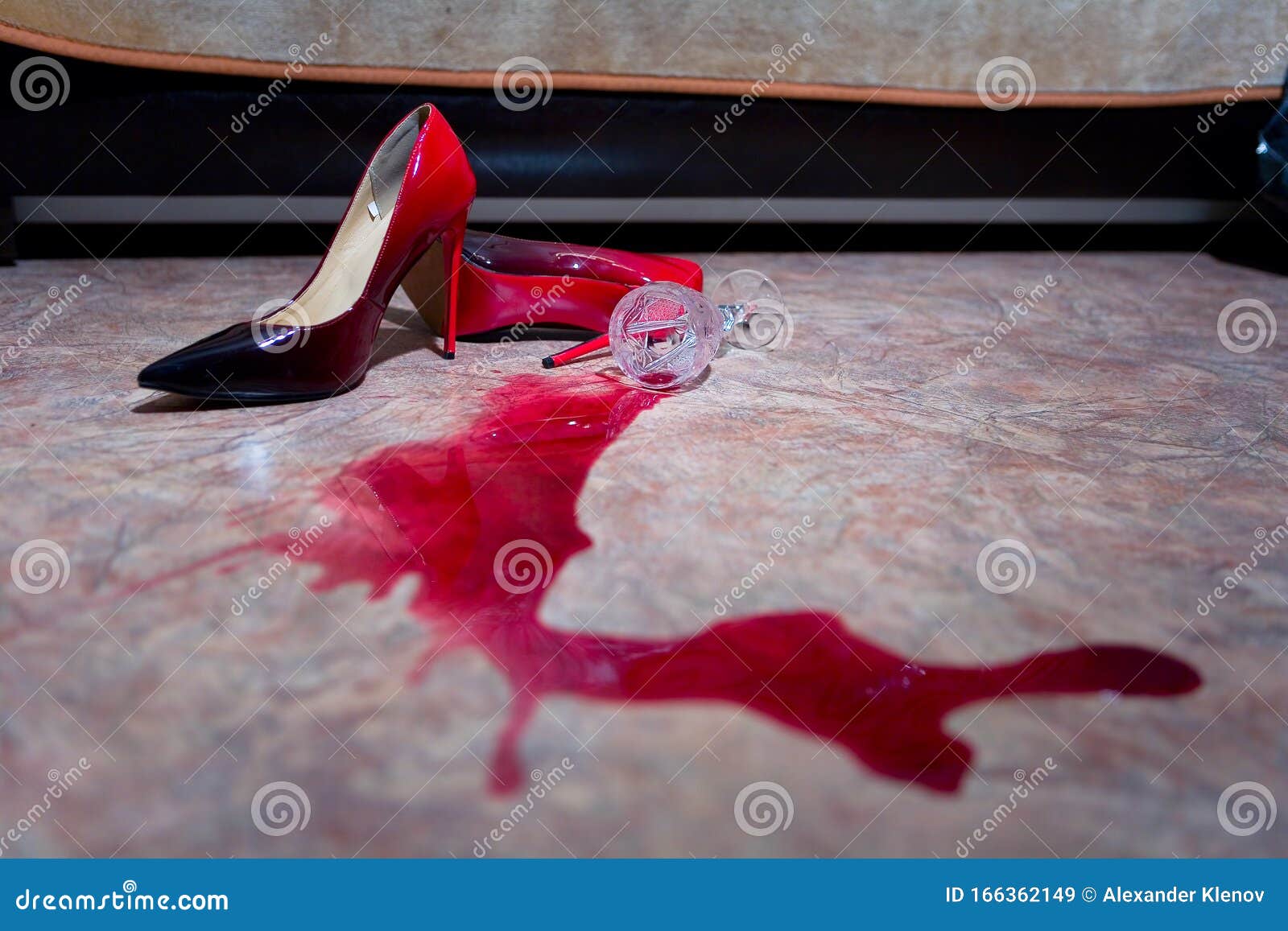 a spilled glass of wine and women`s shoes on the floor