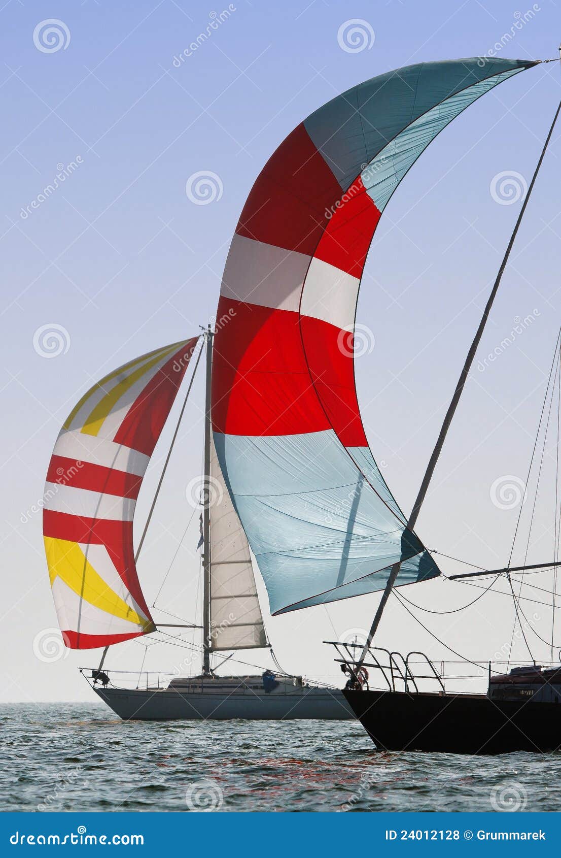 Spinnakers on the Wind. Sailing boats with spinnakers in Polish and German lake