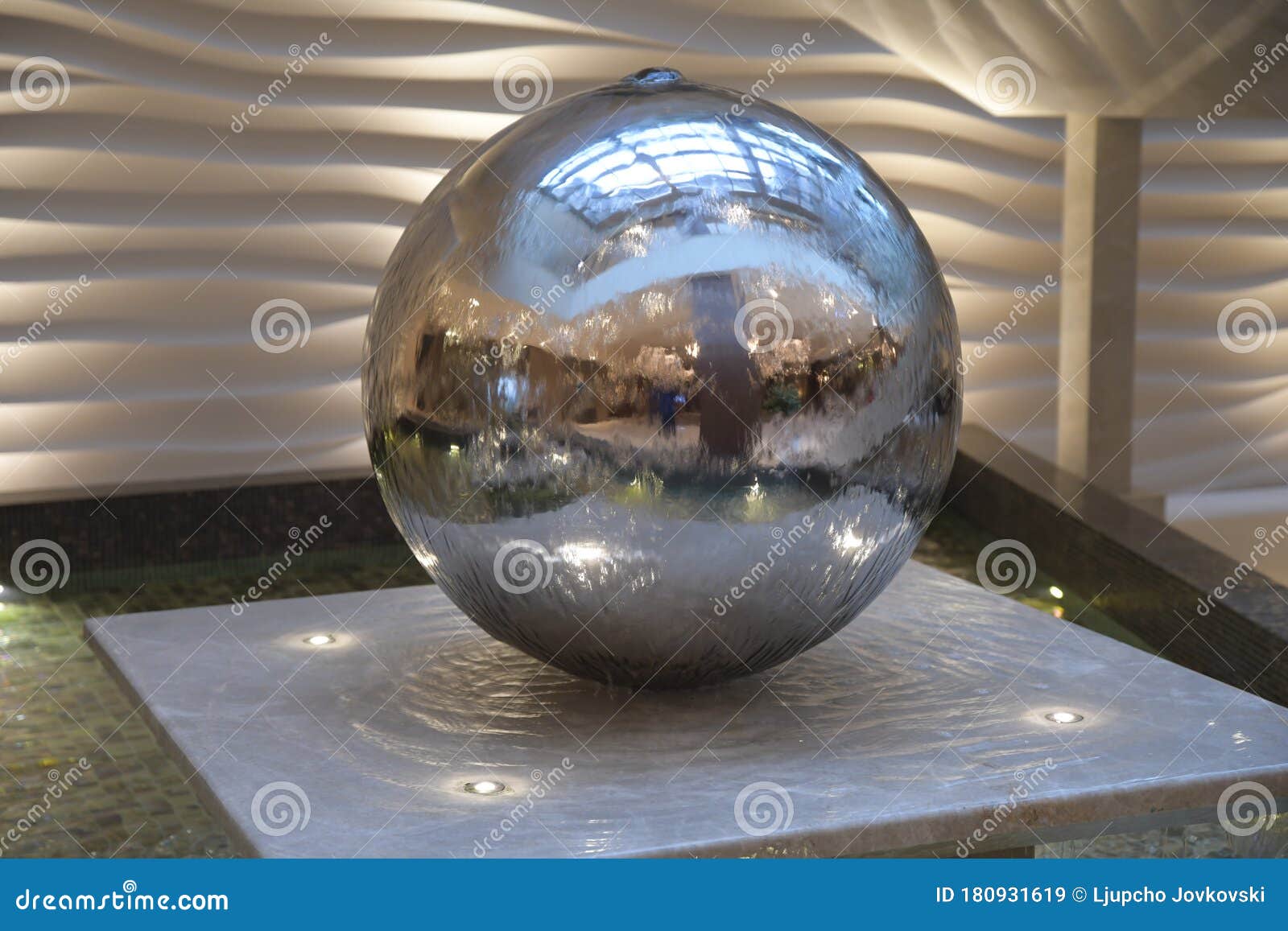 Spinning Reflective Ball Fountain. Water Fountain in the Form of a Ball