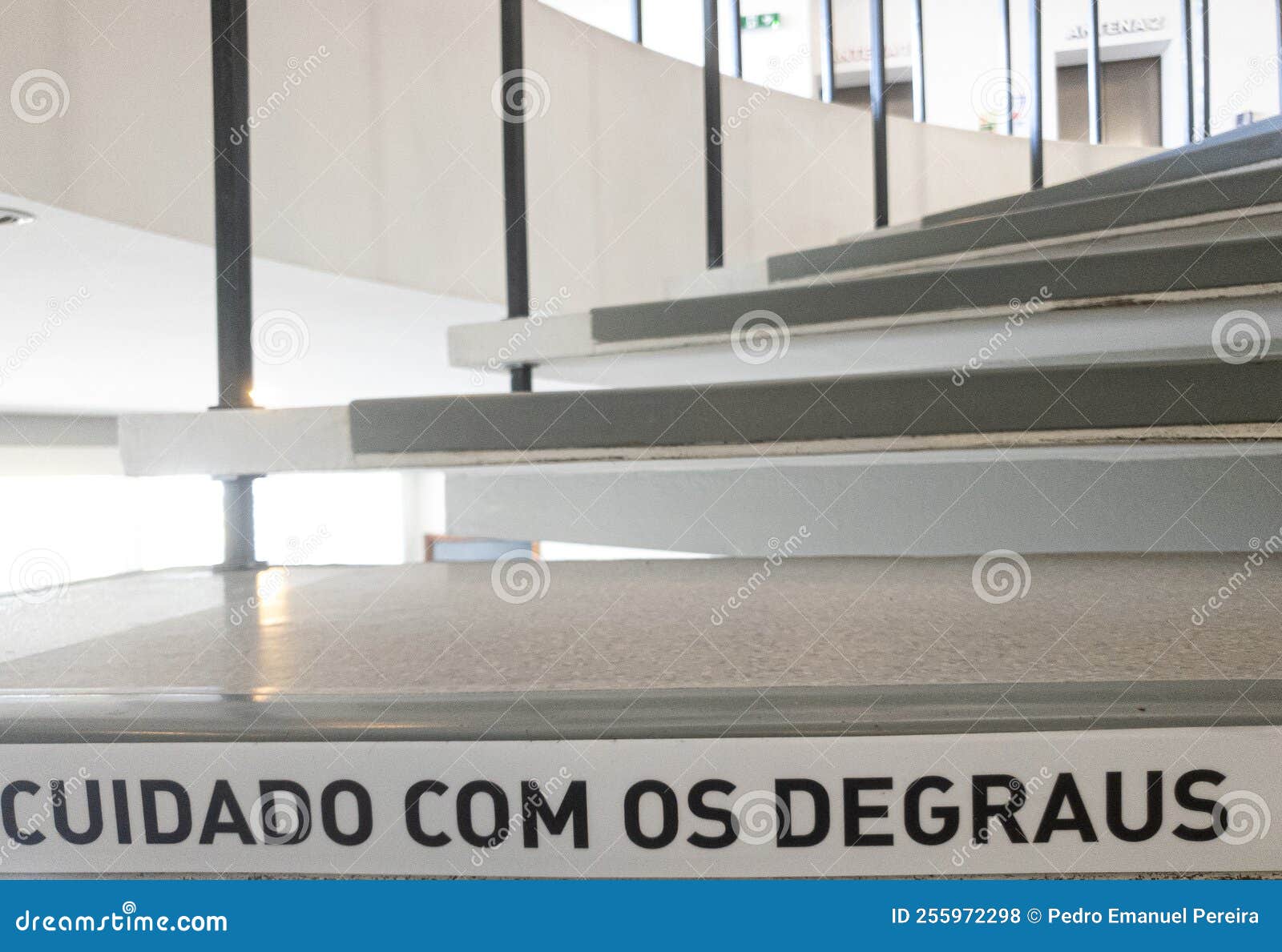 spiral stairs with the warning phrase written in portuguese, "cuidado com os degraus".