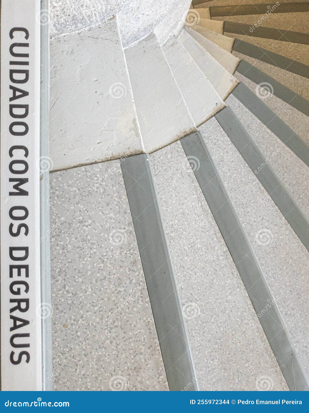 spiral stairs with the warning phrase written in portuguese, "cuidado com os degraus".
