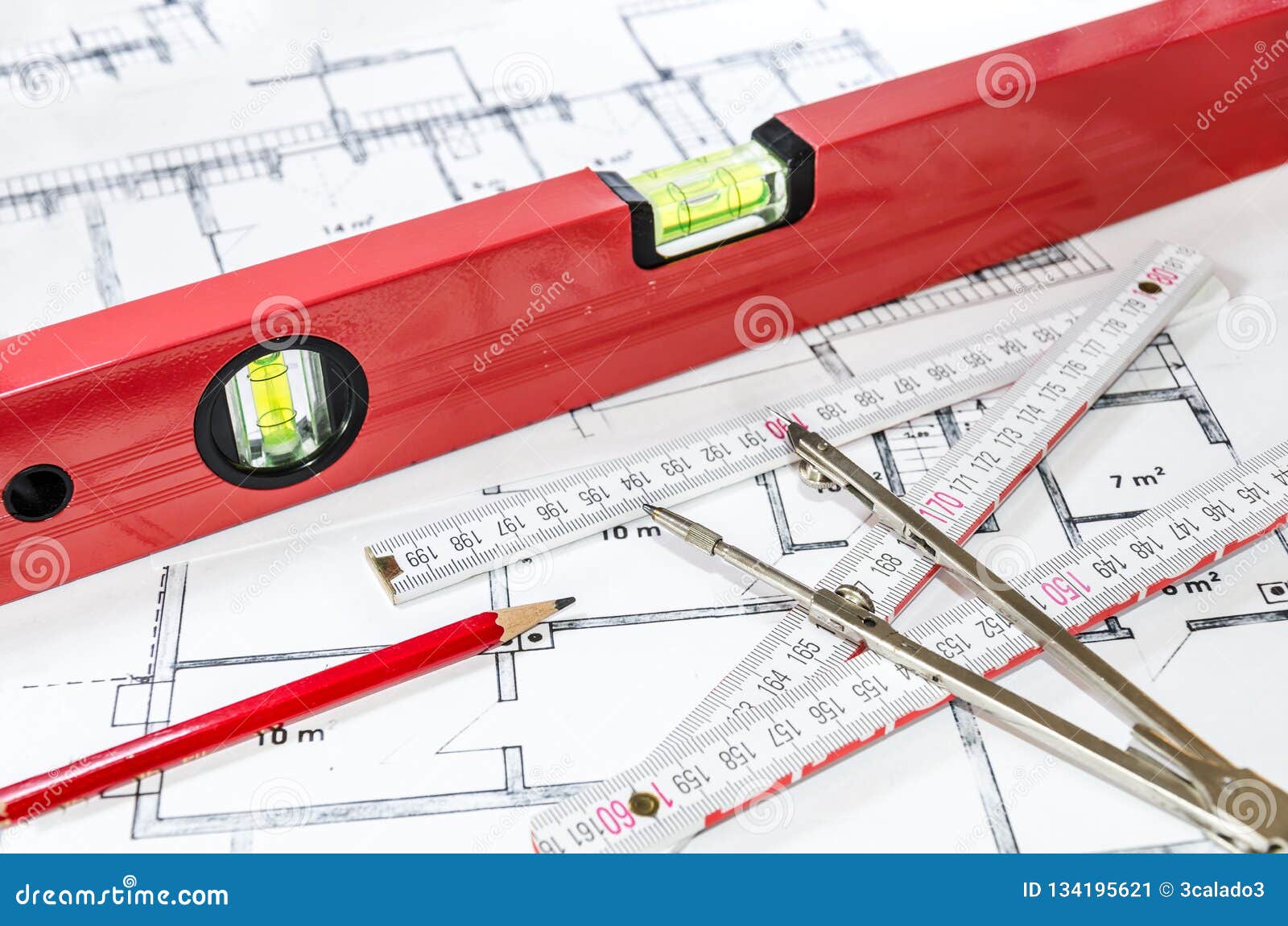 spirit level and other measurement equipment lying on generic building plan